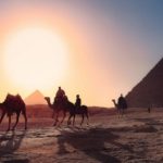 men-and-camels-next-to-egyptian-pyramids-sunset